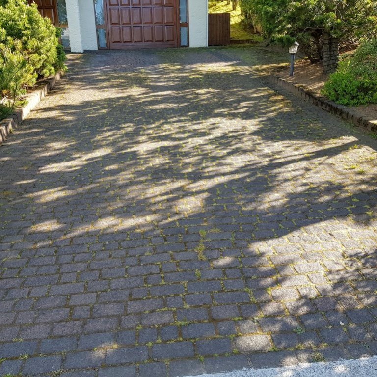 Helluhreinsun á bílaplani með helluburstum