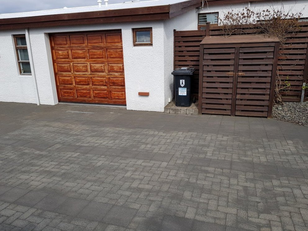 Hér er verið að sópa fúgusandi fram og til baka yfir hellulögnina.