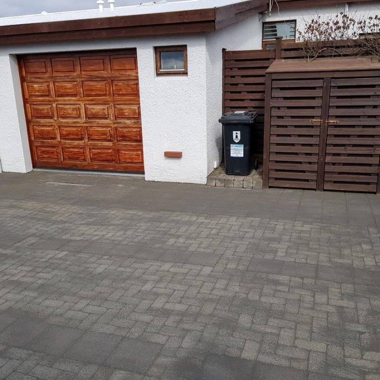 Hér er verið að sópa fúgusandi fram og til baka yfir hellulögnina.